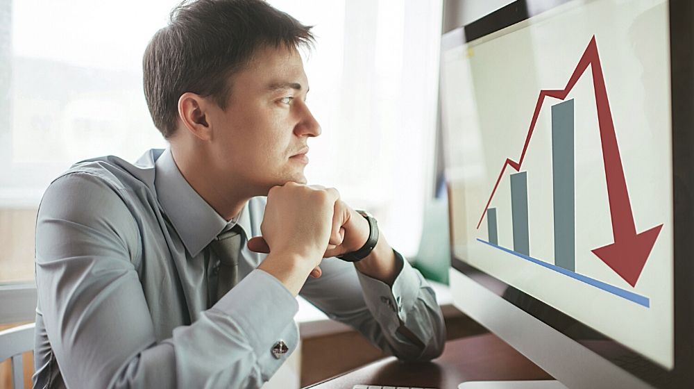 Frustrated stressed shocked business man with financial market chart graphic going down