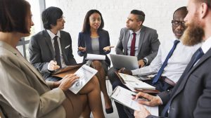 Group of 6 business people discussing in a meeting room