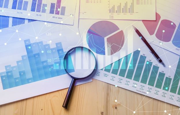 Magnifying glass and documents with analytics data lying on table | Research and Preparation