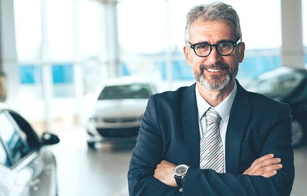 Manager crossed arms in car showroom | How Sales Managers Succeed
