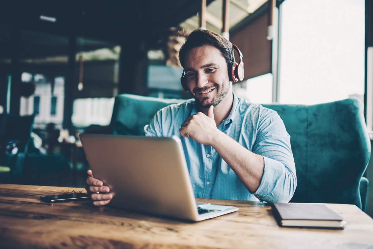 man using his laptop with headphones | Why You Should Have a Virtual Meeting to Build Pipeline | virtual event