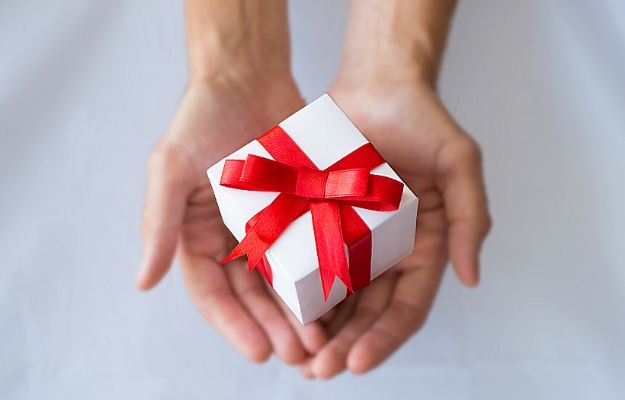 The man hands holding white gift box with red ribbon | Reward customers