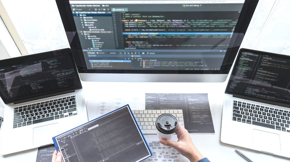 a man working with computer and ipad