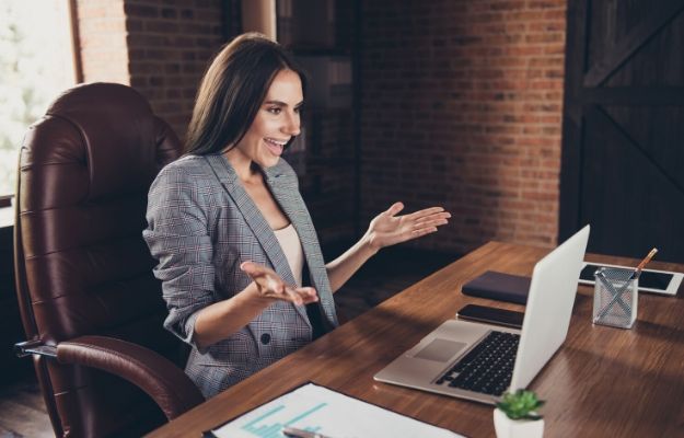 a woman in suit is taking on computer by the working desk | Build an Excellent Sales Culture