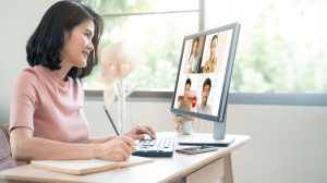 Asian woman holding a meeting with coworkers via videocall