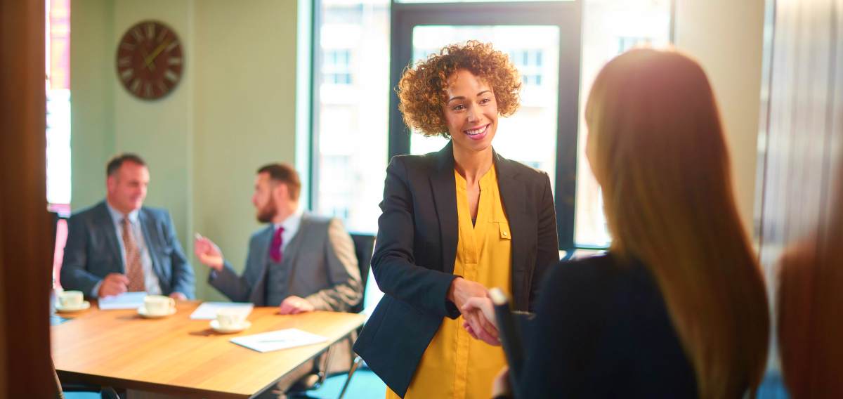 Two woman shaking hands | The Five Traits of Great Leaders