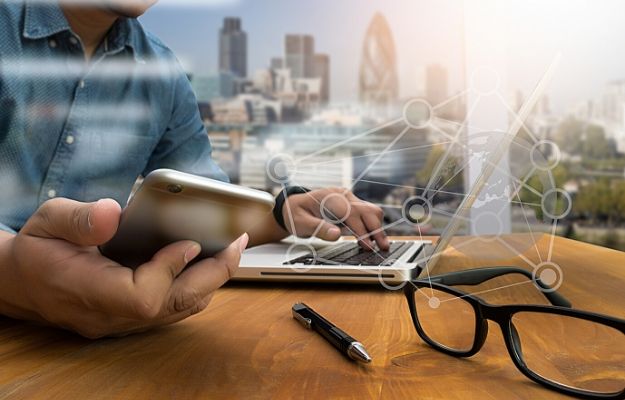 business man hand working on laptop computer on wooden desk with social media network diagram | Get Social