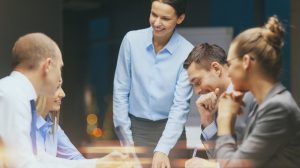 Smiling female boss talking to business team