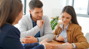 Couple meeting financial adviser for home investment contract