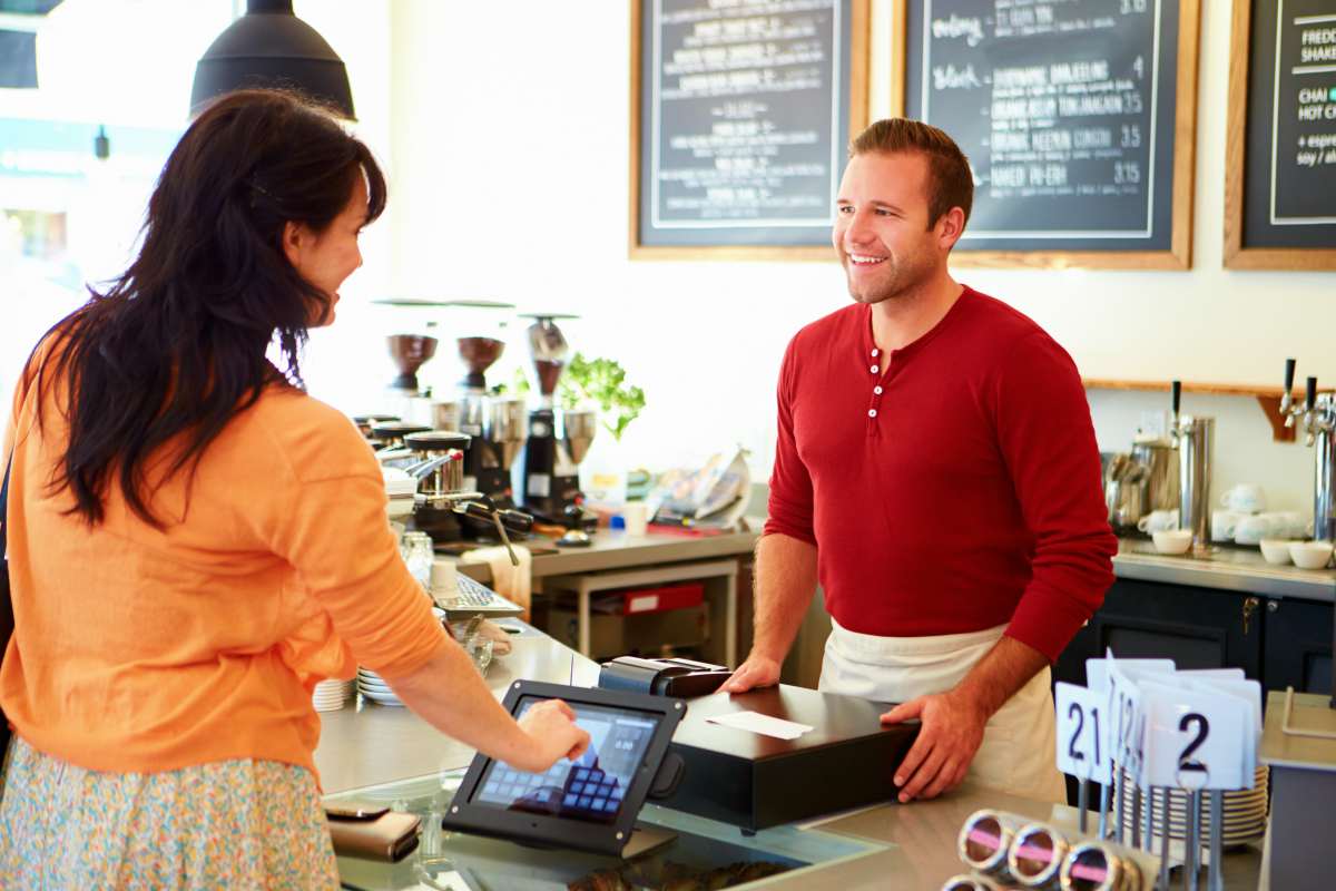 customer paying coffee using touchscreen | Cross Selling And How It Can Drive Growth and Profitability To Your Business | cross-selling | cross sellings
