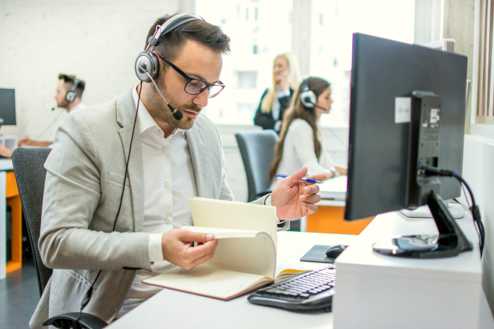 Friendly male taking notes while talking with client | How to Master Pre-Call Planning with Jeff Boyle at Cision (PODCAST) | sales strategy