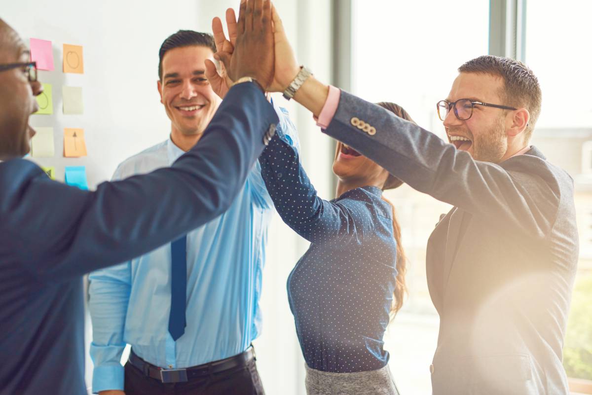 business people giving high fives | Cross Selling And How It Can Drive Growth and Profitability To Your Business | cross-selling | what is cross-selling in retail