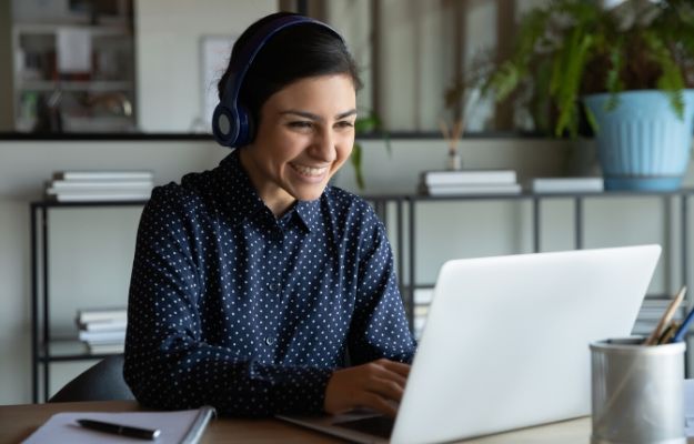 happy young female manager wearing wireless headphones looking at the screen | Not too personal