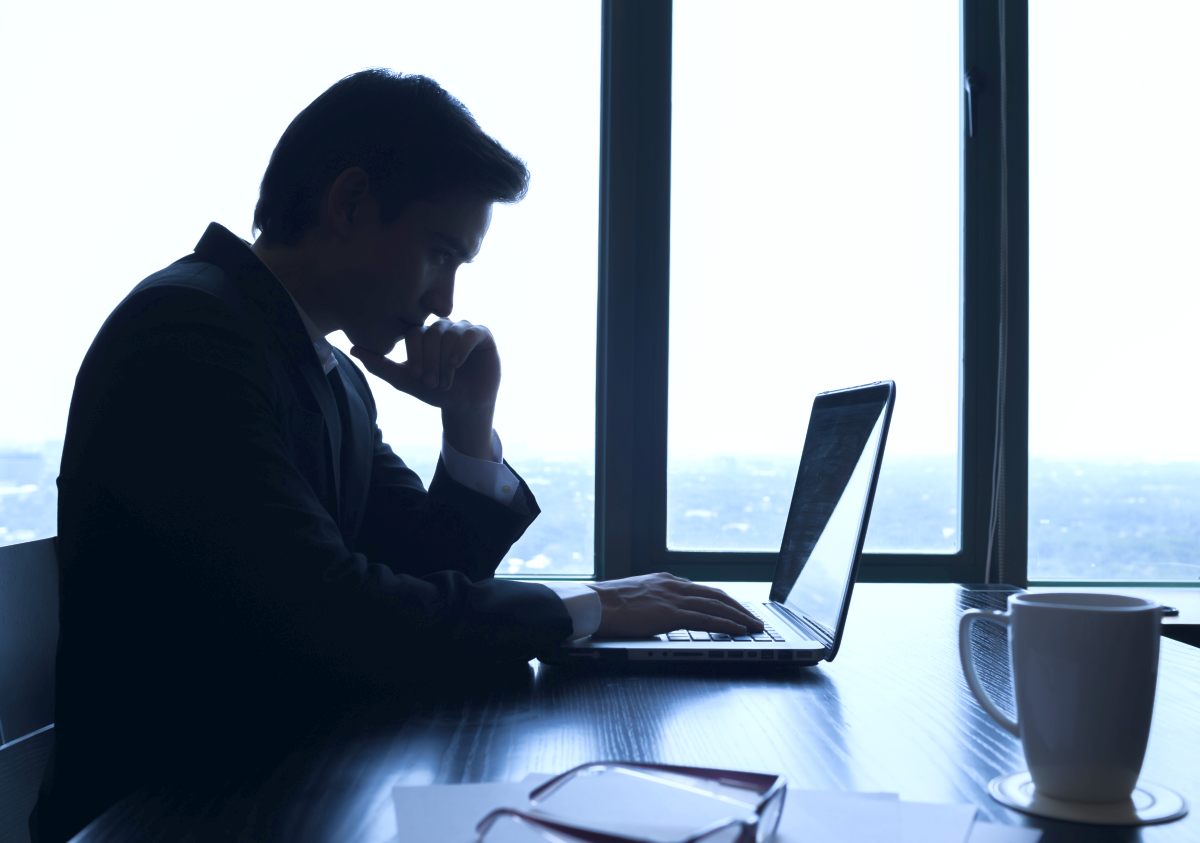 Silhouette of businessman using laptop in the office | Cold Calling Secrets: How To Eliminate Fear, Failure, And Rejection | sales dialer