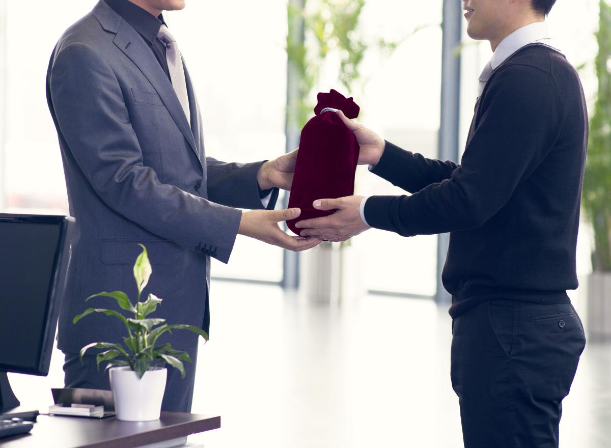 businessman receiving gift from a sales person | Should You Be Using Text In Sales | text sales | cold texting prospects