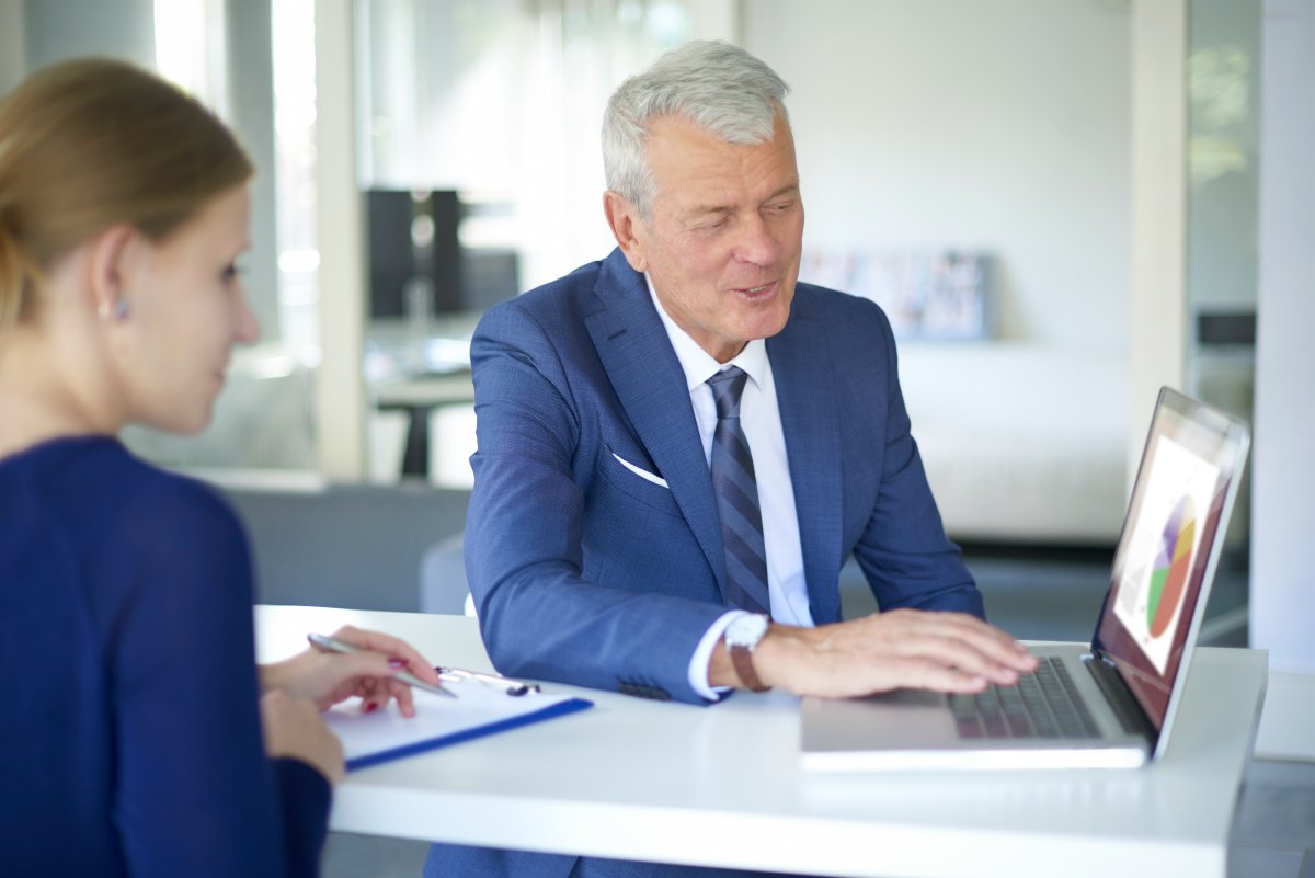 senior businessman explaining work to woman officemate teammate | How To Support Frontline Sales Managers w/Natalie Bering @ServiceNow | frontline managers | front line managers