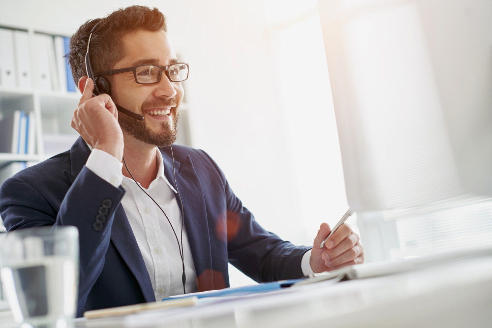 Smiling businessman using headset when talking to customer | Effective Cold Calling Tips For B2B | sales prospecting | b2b cold calling