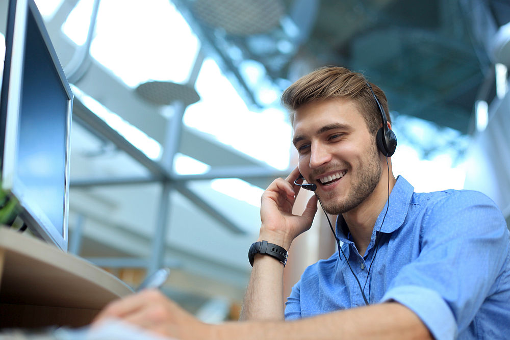 Smiling friendly handsome young male call centre operator | Ice Breakers Sales Reps Can Use to Ramp Up Conversions | Ice Breaker Sales | ice breakers ice cubes