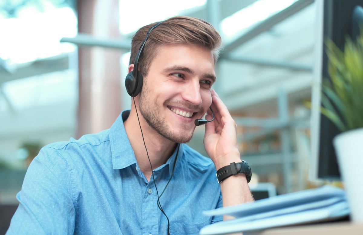man smiling taking calls | Ways A Predictive Dialer Can Increase Your Business | predictive dialer software