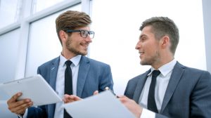 Young business people looking at each other and talking at the office