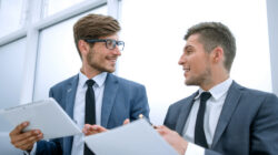 Young business people looking at each other and talking at the office